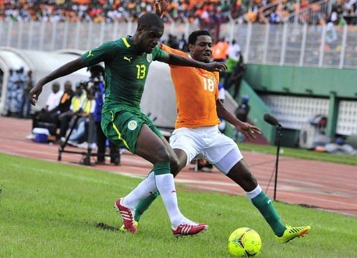 Ivory Coast's Kader Keita (R) fights for the ball with Senegal's Jacques Doudou Faty
